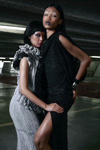 two women posing in a parking garage